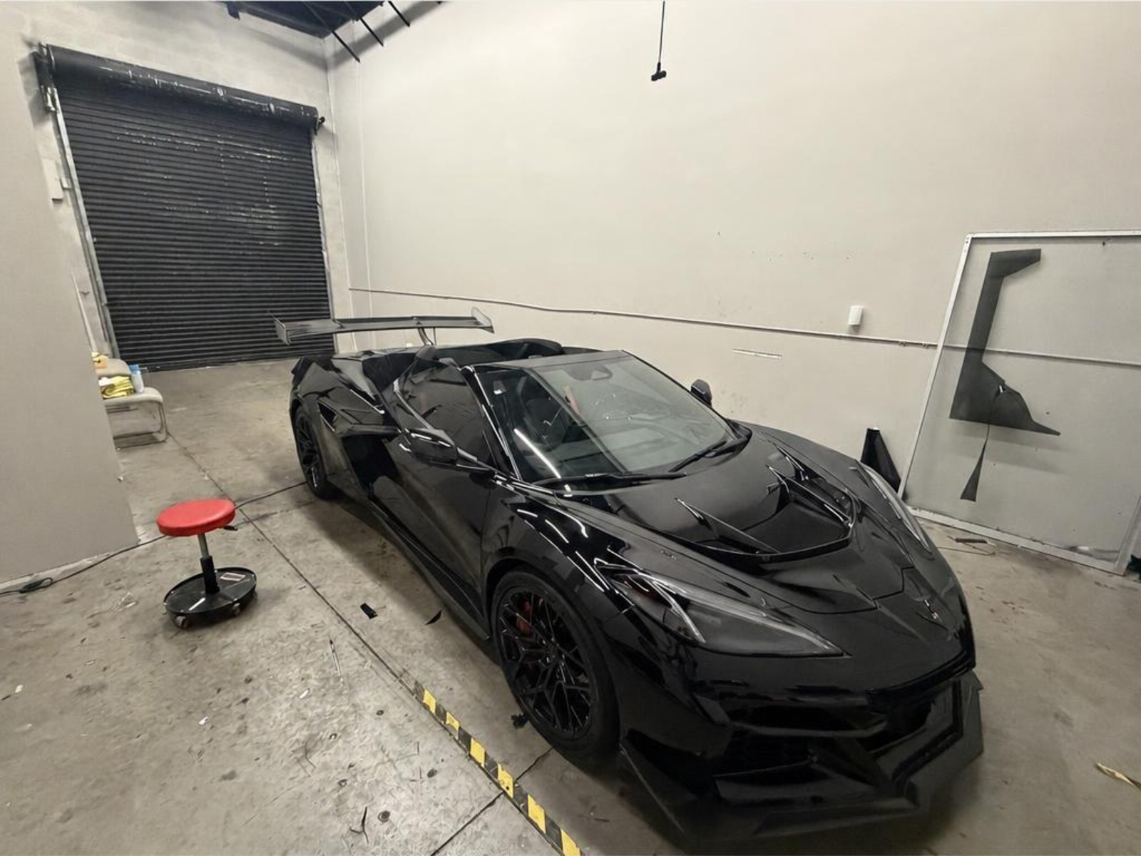 Black Chevrolet Corvette sports car inside the Tamiami Tint of Naples shop for window tinting