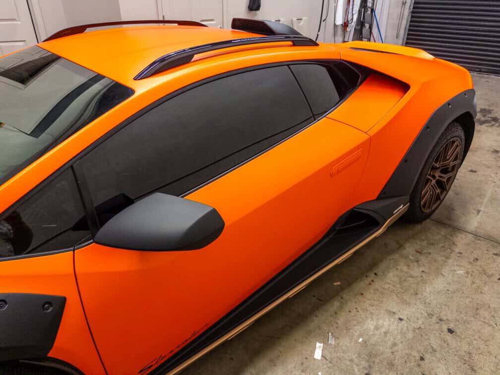 Orange Lamborghini Huracán Sterrato in the Tamiami Tint of Naples shop during window tint installation