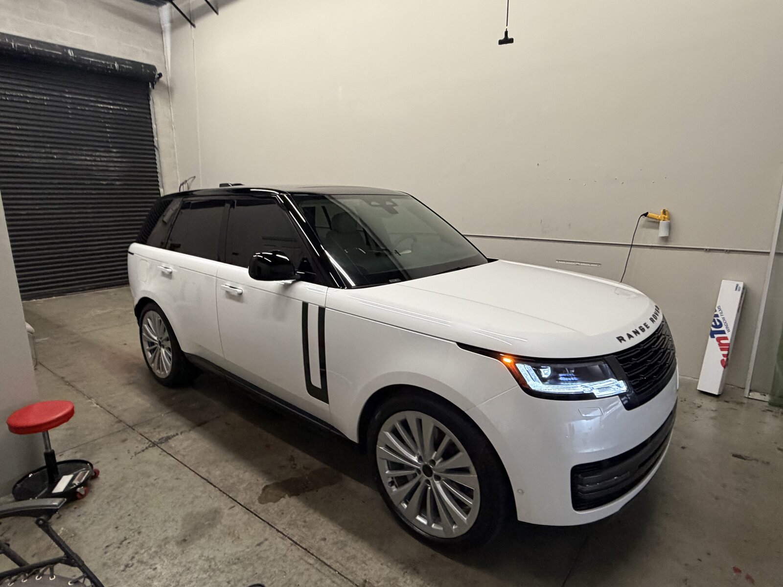 White Land Rover Range Rover luxury SUV with dark tinted windows at Tamiami Tint of Naples