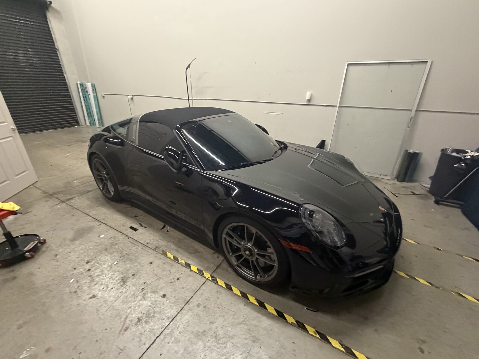 Black Porsche 911 Targa with tinted glass inside the Tamiami Tint of Naples shop